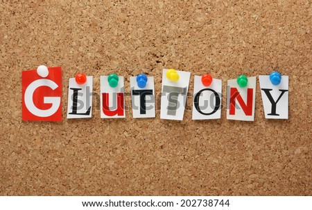 The word Gluttony, one of the seven deadly sins in cut out magazine letters pinned to a cork notice board