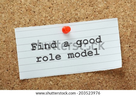 The phrase Find A Good Role Model typed on a piece of paper and pinned to a cork notice board