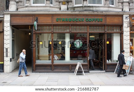 London, England - Sept 11, 2014: People passing by and entering a Starbucks store in Central London, England. Starbucks has outlets in more than 50 countries worldwide.
