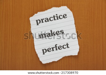The phrase Practice Makes Perfect typed on a piece of lined paper and laid on a false wooden background or desktop
