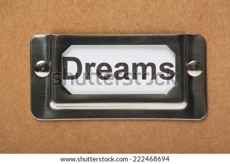 Drawer label in a holder on a cardboard box with the word Dreams typed onto the index card