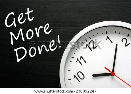The phrase Get More Done written on a blackboard next to a modern office wall clock. A Time Management concept