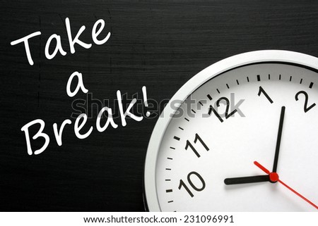The phrase Take A Break written on a blackboard next to a modern office clock. A reminder to find time in your busy schedule to relax