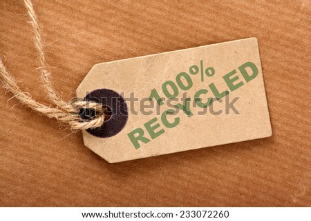 The phrase One Hundred Recycled on a Luggage Label or tag with string on brown wrapping paper
