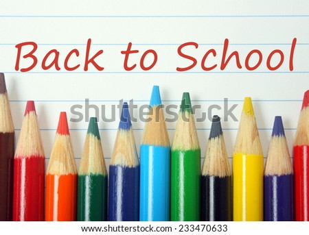The phrase Back To School written on lined paper above a row of coloring pencils