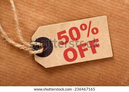 Fifty percent off announcement message in red text on a brown paper price tag and wrapping paper with string