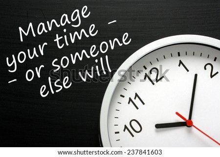 The phrase Manage your time - or someone else will, written on a blackboard next to a modern clock.