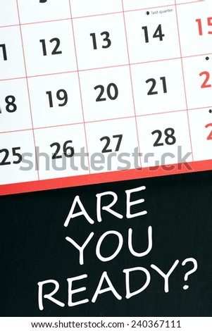 The phrase Are You Ready written on a blackboard below the pages of a wall calendar