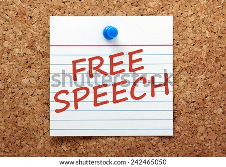 The phrase Free Speech written in red ink on a lined index card and pinned to a cork notice board