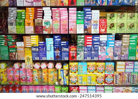 London, England - January 24, 2015: Window display of chocolate coated biscuit sticks, cookie rolls and other sweet snacks in an Asian supermarket in the Chinatown district of London, England