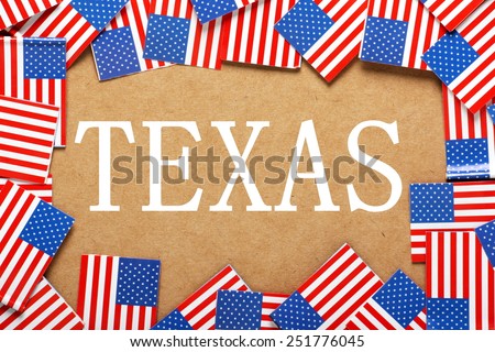 Miniature flags of the United States of America form a border on brown card around the word Texas