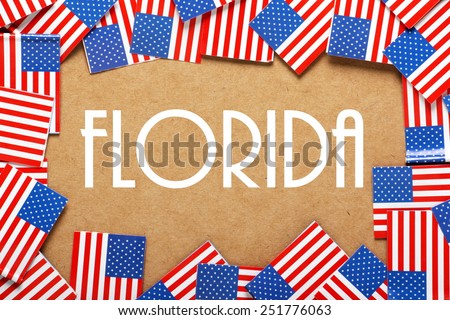 Miniature flags of the United States of America form a border on brown card around the word Florida