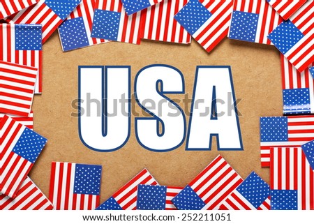 Miniature flags of the United States of America form a border on brown card around the title USA, the abbreviation for United States of America