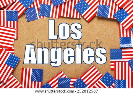 Miniature flags of the United States of America form a border on brown card around the name of the city of Los Angeles