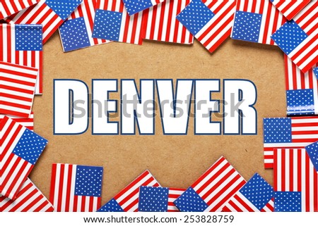 Miniature flags of the United States of America form a border on brown card around the name of the city of Denver