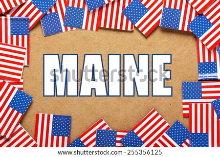 Miniature flags of the United States of America form a border on brown card around the name of the state of Maine
