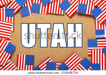 Miniature flags of the United States of America form a border on brown card around the name of the state of Utah