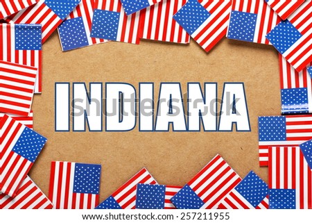 Miniature flags of the United States of America form a border on brown card around the name of the state of Indiana