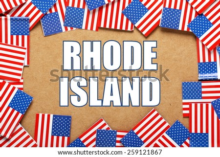 Miniature flags of the United States of America form a border on brown card around the name of the state of Rhode Island
