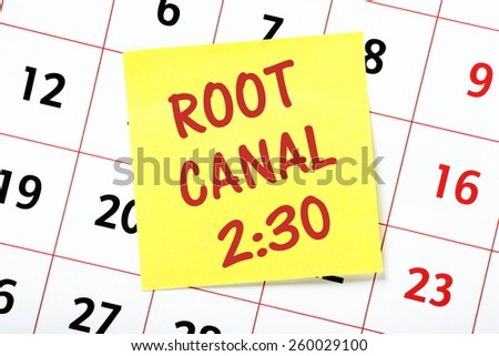 A reminder for your Root Canal treatment appointment at the dentist on a yellow sticky note attached to a wall calendar