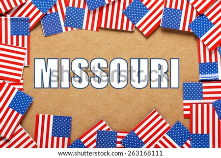 Miniature flags of the United States of America form a border on brown card around the name of the state of Missouri