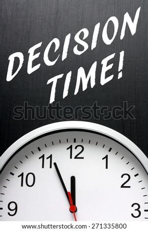 The phrase Decision Time in white text on a blackboard above a modern clock face with the time at almost midnight or twelve noon