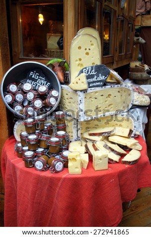 London, England - April 02, 2015: A display of Emmental cheese rounds and jars of sauce on a stall in Borough Market, London. The market has traded in Southwark, London for more than 250 years