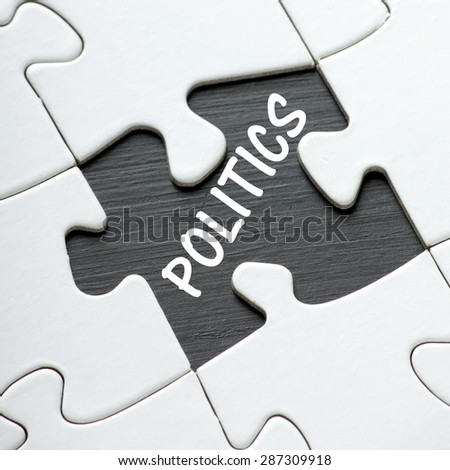The word Politics in white text on a blackboard revealed by a missing jigsaw puzzle piece
