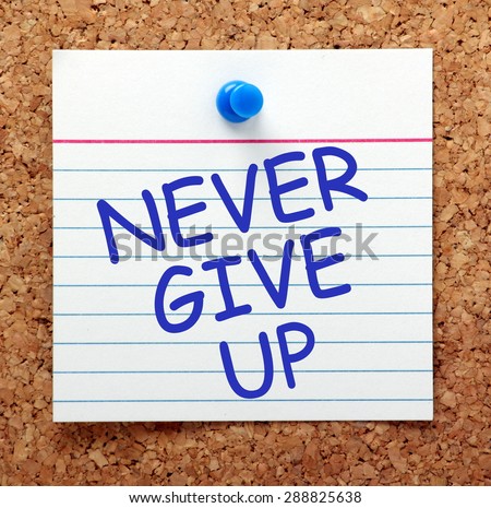 The phrase Never Give Up in blue ext on a note card pinned to a cork notice board as a reminder