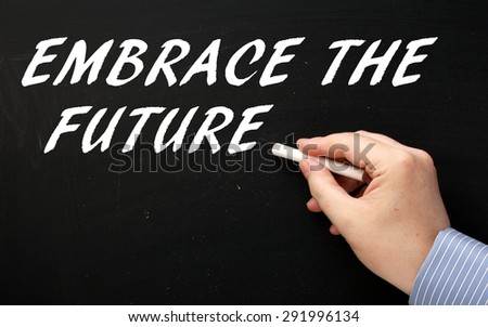Male hand wearing a business shirt writing the phrase Embrace The Future in white text on a blackboard as a reminder to accept change and new processes