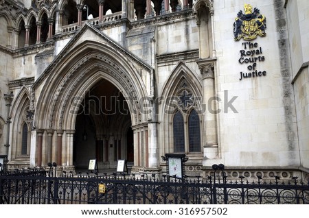 London, England - Sept 09, 2015: Exterior facade of the Royal Courts of Justice in London, England showing the coat of arms of the courts and the archway of the main entrance