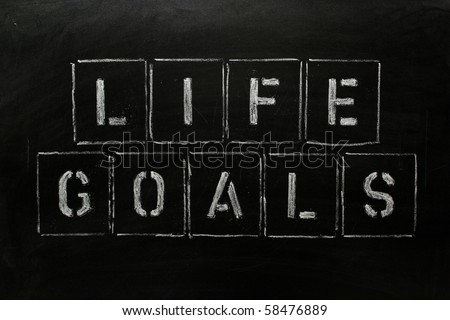 The phrase LIFE GOALS in stencil letters on a blackboard