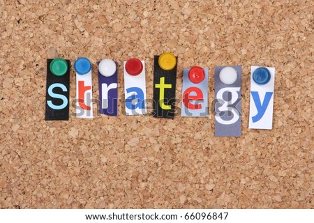 The word Strategy in cut out magazine letters pinned to a cork notice board as a business concept