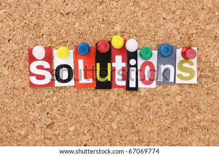 The word Solutions in cut out magazine letters pinned to a cork notice board