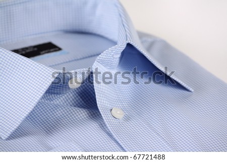 Close up view of a generic blue business shirt with a check pattern on a white background