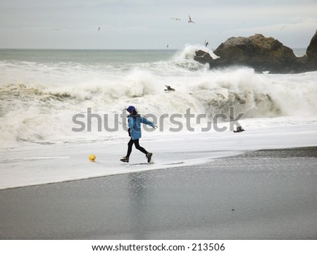 Woman runs into pounding surf to rescue a balloon at Rockaway Beach in Pacifica, CA