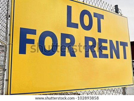 Lot for rent sign posted on a metal fence.