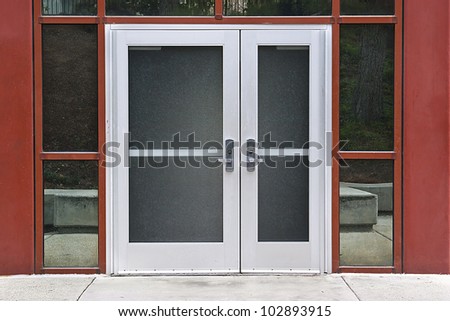 Outside solid glass door with building exterior is red.