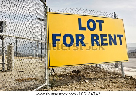 Posted rent sign on a metal fence.