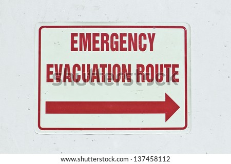 Emergency sign shows an arrow for the evacuation route.