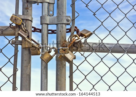 Multiple padlocks used on a chain link fence help keep it lock and close.