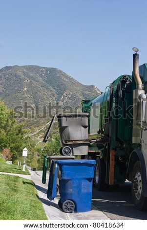 Garbage vehicle picks up a trash bin.