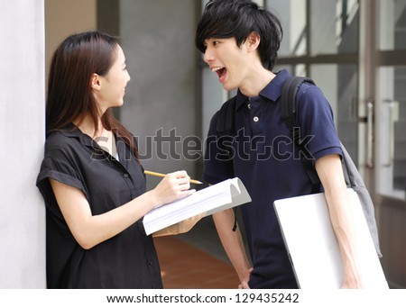 Asian college couple student standing holding laptop on campus