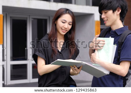 college couple student olding laptop on campus