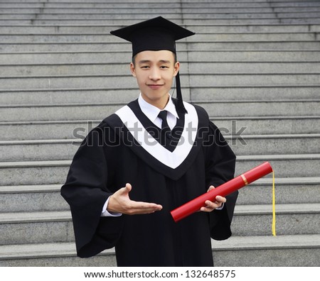 Young man with graduation cap and gown and diploma