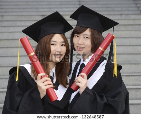 two young girl with graduation cap and gown and diploma