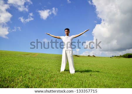 young yoga man on field rising up his hands young yoga man on field rising up his hands