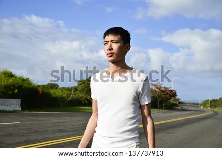 Young man walking on the road outdoor shot