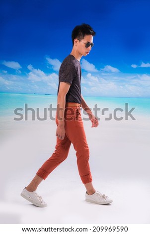 Full body sunny man with sunglasses walking in outdoor at beach background