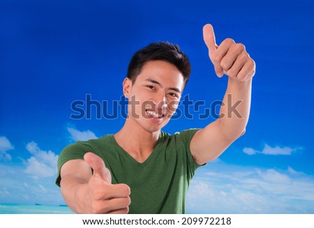 young man with thumbs up on a blue sky background